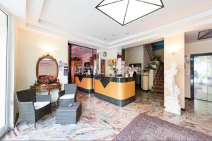 a salon with a counter and chairs and a mirror at Hotel Delizia in Rimini