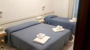 Habitación con 2 camas y toallas. en Hotel Delizia en Rímini