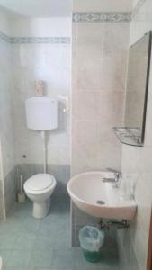 bagno bianco con servizi igienici e lavandino di Hotel Delizia a Rimini