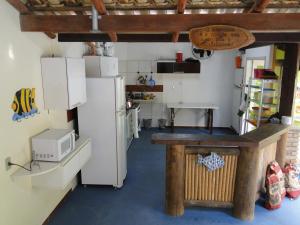 eine Küche mit einem weißen Kühlschrank und einer Mikrowelle in der Unterkunft Céu Azul Casa de Praia in São Sebastião + 38 Fotos