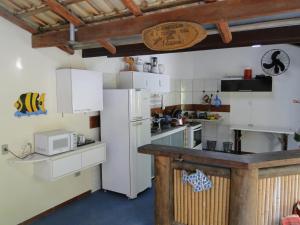 eine Küche mit einem weißen Kühlschrank und einer Mikrowelle in der Unterkunft Céu Azul Casa de Praia in São Sebastião