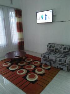 Penginapan Rezki Syariah في بوكيتينجى: غرفة معيشة مع أريكة وطاولة على سجادة