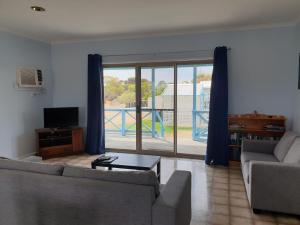 a living room with a couch and a sliding glass door at Marion Bay Holiday Villas in Marion Bay