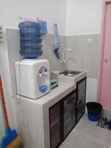 eine Küche mit einer Spüle und einer Mikrowelle in der Unterkunft Penginapan Rezki Syariah in Bukittinggi