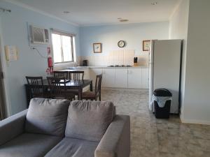 a living room with a couch and a kitchen at Marion Bay Holiday Villas in Marion Bay