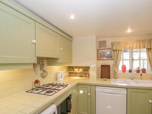 a kitchen with green cabinets and a stove top oven at 23 Clifford Chambers in Stratford-upon-Avon
