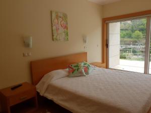 1 dormitorio con cama y ventana en Casinhas do Gerês, en Gerês