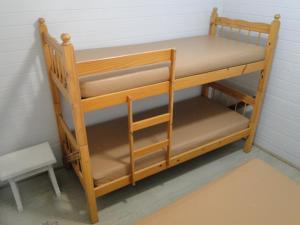 ein Etagenbett aus Holz in einer Ecke eines Zimmers in der Unterkunft Céu Azul Casa de Praia in São Sebastião