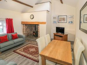 a living room with a couch and a table and a fireplace at Crud yr Awel in Bangor