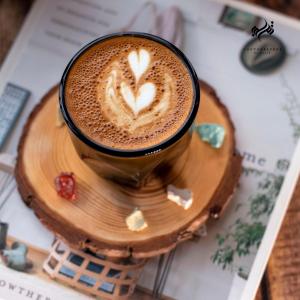 uma chávena de café sentada numa mesa em تــرامونتــان em Hail
