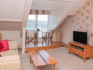 ein Wohnzimmer mit Couch und Fernseher in der Unterkunft Manor Studio in Dartmouth