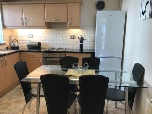 eine Küche mit Tisch und Stühlen und einem Kühlschrank in der Unterkunft 2 Catherines City Cottage in Perth