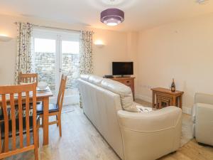 a living room with a couch and a dining room at 7 Malt House Court in Watchet