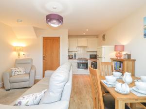 a living room with a white couch and a table at 7 Malt House Court in Watchet