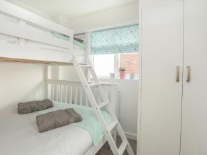 a bunk bed with two pillows on it in a room at Sisial-Y-Mor in Rhosneigr