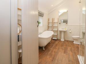 ein Badezimmer mit Badewanne, Toilette und Waschbecken in der Unterkunft Lakeside Cottage in Macclesfield + 20 Fotos