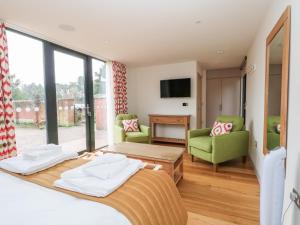 a bedroom with a bed and a living room at Lakeside Village & The Potting Shed in Macclesfield