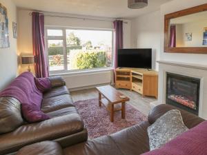 sala de estar con sofá y chimenea en The Bungalow at Mill Falls, en Great Driffield