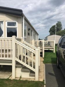 a mobile home with a porch and a deck at 14A kingfisher court in Tattershall