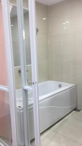 a white bath tub sitting in a bathroom at Hotel MAI TUAN Phạm Hùng in Ấp Trường Huê +8 photos