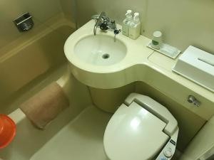 a small bathroom with a toilet and a sink at Osaka Ryokan Kuramoto in Osaka