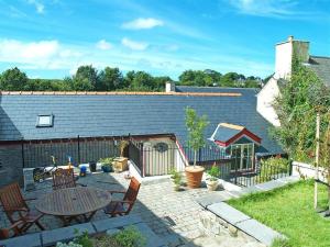 a backyard with a table and chairs and a fence at Stable Cottage, Cardigan in Cardigan