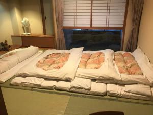 a large bed in a room with a window at Osaka Ryokan Kuramoto in Osaka