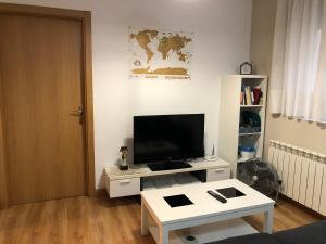 a living room with a television and a white table at EL RINCÓN de LOLI - Lic UAT607 in Pamplona