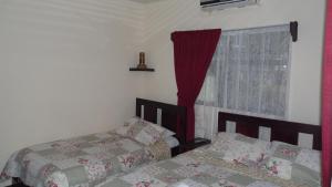 a bedroom with two beds and a window at Hotel Arboleda in Quepos