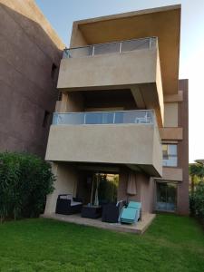een groot gebouw met stoelen en een balkon bij Prestigia appartement opale in Marrakesh