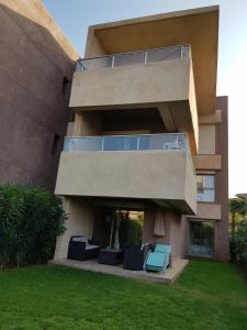 a large building with chairs and a balcony at Prestigia appartement opale in Marrakesh