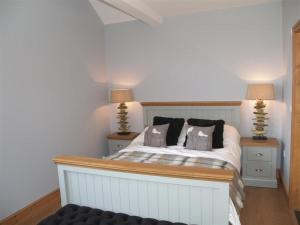 a bedroom with a white bed with two lamps at Seabrook in Haverfordwest