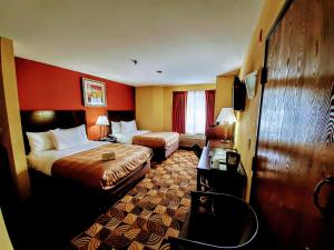 a hotel room with two beds and a red wall at Quality Inn Brunswick Cleveland South in Brunswick +17 photos