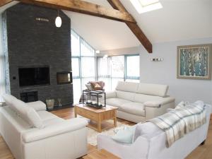 a living room with white furniture and a fireplace at Seabrook in Haverfordwest