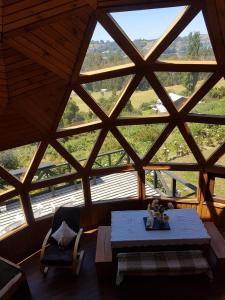 カストロにあるTurismo del Bosqueのテーブルと大きな窓が備わる広い客室です。