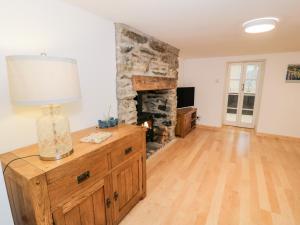 uma sala de estar com uma lareira de pedra e um candeeiro em Pentowyn em Holyhead