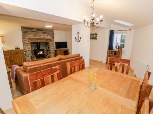 uma sala de jantar e sala de estar com uma mesa de madeira em Pentowyn em Holyhead