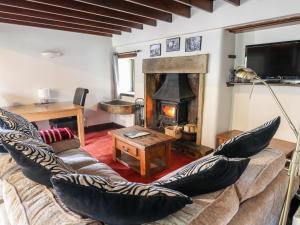 a living room with a couch and a fireplace at Monks Cottage in Skipton