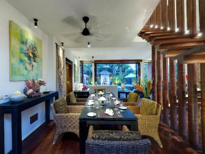 comedor con mesa y sillas en Majapahit Beach Villas by Nakula, en Ketewel