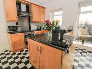 una cocina con una encimera con un jarrón de flores. en Tynemouth Village Penthouse en North Shields