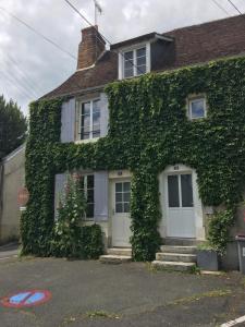 サン・テニャンにあるLes Gites Saint Aignan - Proche du Zoo de Beauvalの白いドアと階段のあるツタに覆われた家