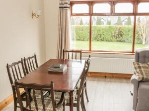 a dining room table with chairs and a window at Castle View in Oughterard