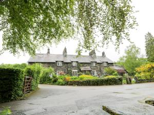 ein altes Steinhaus mit Garten davor in der Unterkunft Ednas Cottage in Ambleside