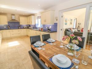 a kitchen and dining room with a wooden table and chairs at Atlantic Reach in Bude