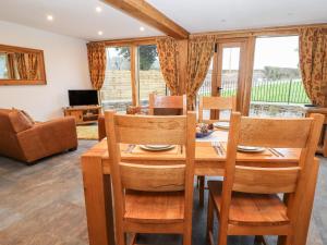 a dining room with a wooden table and chairs at The Old Cart House in Oswestry