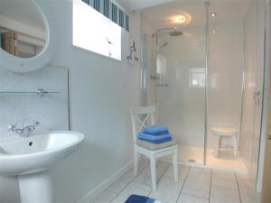 a white bathroom with a sink and a shower at Pond Cottage in New Quay +16 photos