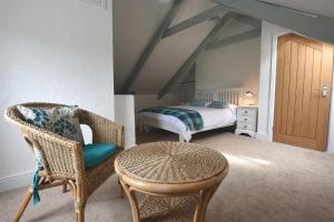 a bedroom with a bed and a chair and a table at The Old Farmhouse Kitchen in Haverfordwest