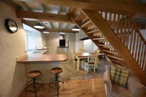 a kitchen and dining room with a spiral staircase at The Old Farmhouse Kitchen in Haverfordwest