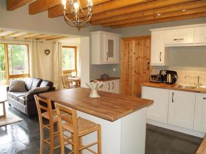 cocina y sala de estar con mesa y sillas en Dan Castell Cottage en Llandeilo