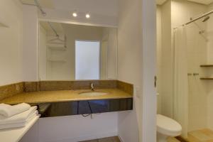a bathroom with a sink and a toilet and a mirror at Express Floripa Residence in Florianópolis +43 photos